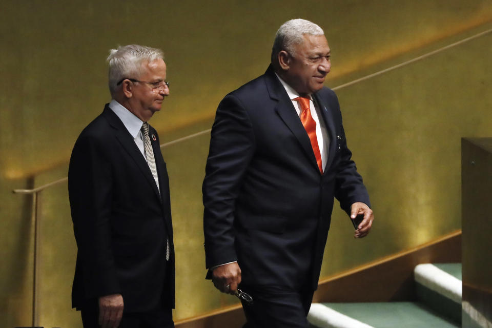 Fiji's Prime Minister Josaia Voreqe Bainimarama, right, is escorted to address the 73rd session of the United Nations General Assembly, at U.N. headquarters, Friday, Sept. 28, 2018. (AP Photo/Richard Drew)