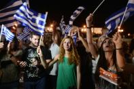 People celebrate in Athens after partial referendum results indicate a big majority for the 'No' vote