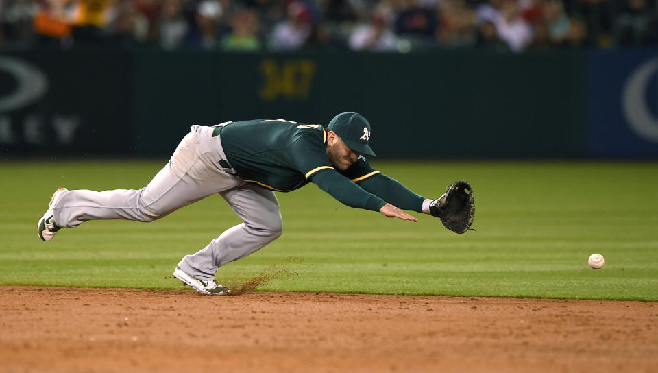 Oakland Athletics shortstop Nick Punto can't reach a ball hit for a single by Los Angeles Angels' Erick Aybar during the third inning of a baseball game, Wednesday, April 16, 2014, in Anaheim, Calif. (AP Photo/Mark J. Terrill)