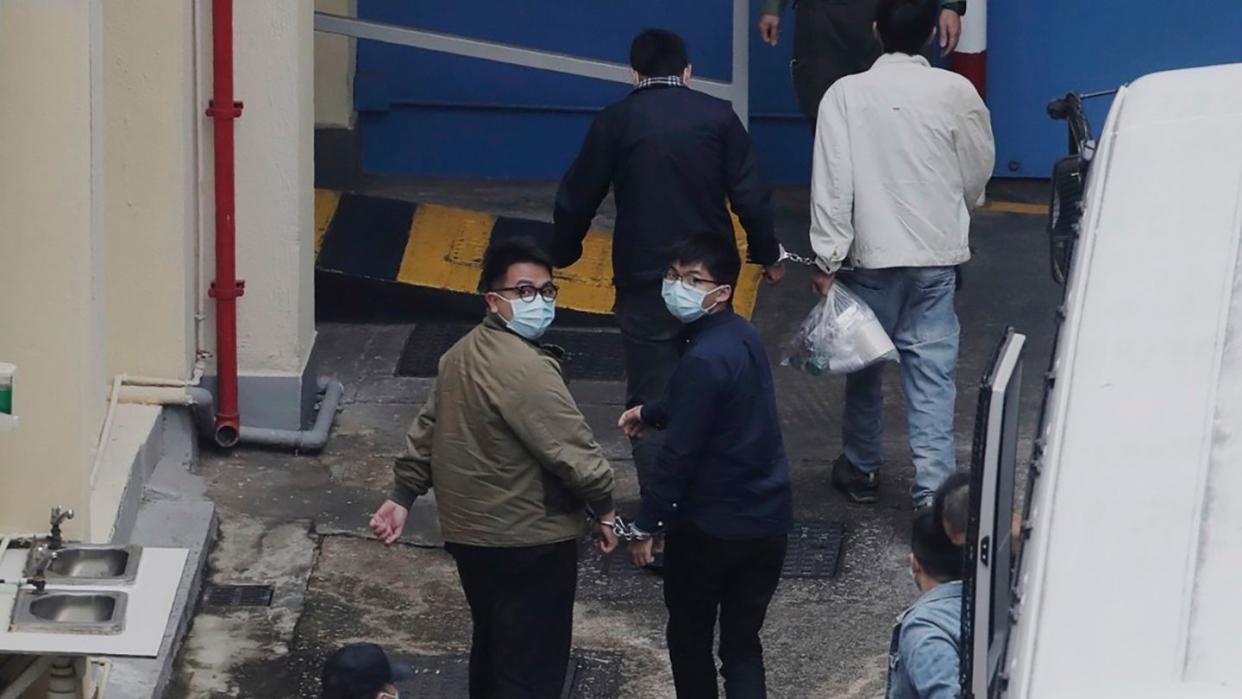 Die Aktivisten Ivan Lam (l.) und Joshua Wong wurden auf einem Gefängnishof in Hongkong von Justizvollzugsbeamten aneinandergekettet. Der prominente Hongkonger Pro-Demokratie-Aktivist Wong und zwei weitere Aktivisten, Lam und Chow, wurden in Gewahrsam genommen.