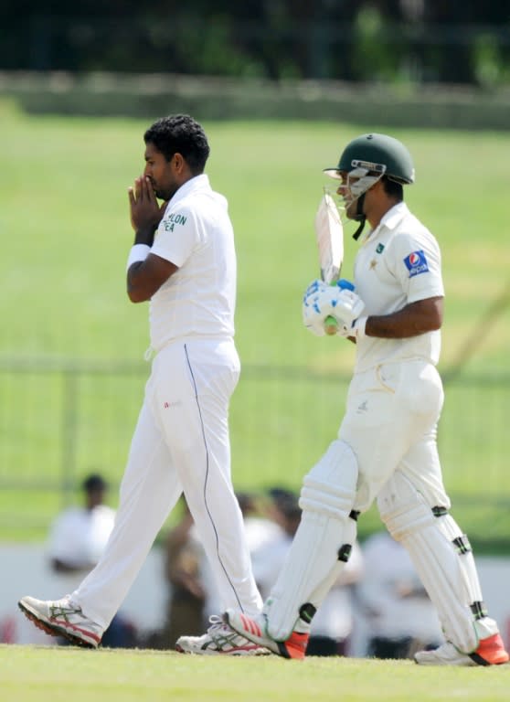 Sri Lanka's Dhammika Prasad (L) following the dismissal of Pakistan's Asad Shafiq (R) during the second day of the third and final Test match in Pallekele on July 4, 2015