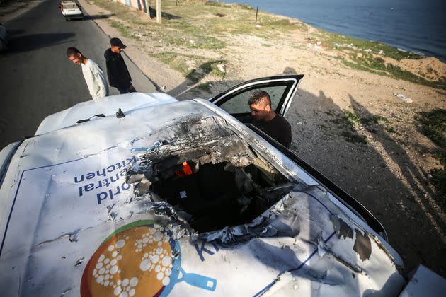 Palestinians stand next to a vehicle in Gaza's Deir al-Balah on April 2, where employees from the World Central Kitchen were killed in an Israeli airstrike.