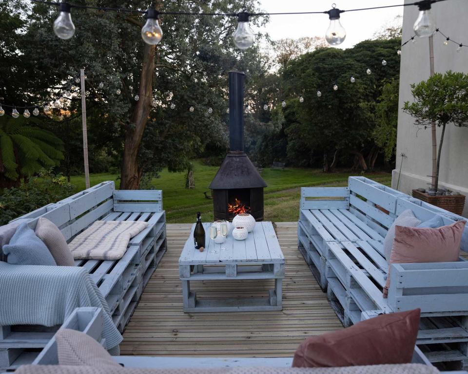 <p> If you're looking for decking ideas on a budget, or simply fancy a project for the weekend, consider building some pallet furniture. Often you can get pallets for a very small cost (sometimes, they're even free), and they're a super versatile material for getting creative with. </p> <p> From coffee tables to chairs and sofas, or even an outdoor bar, the possibilities are almost endless. And with a lick of exterior wood paint, you can really customize them to suit your space. Cushions and throws will add extra comfort, then consider a string of lights overhead and a cozy chiminea nearby to complete the welcoming scene. </p>