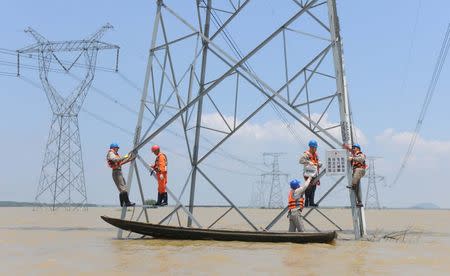Workers reinforce the electric pylons at a flooded area as Typhoon Nepartak approaches in Xuancheng, Anhui Province, China, July 9, 2016. REUTERS/Stringer