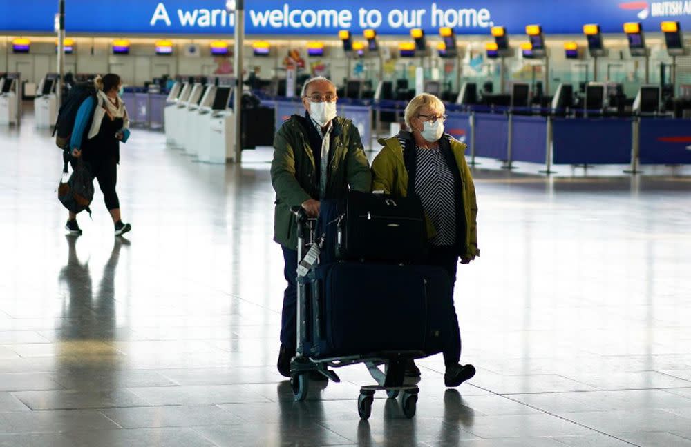 People wearing masks are seen at Heathrow airport in London April 5, 2020. — Reuters pic