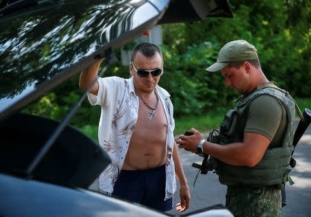 A Ukrainian serviceman checks documents at a checkpoint near Slaviansk in Donetsk region, Ukraine, June 29, 2016. Picture taken June 29, 2016. REUTERS/Gleb Garanich