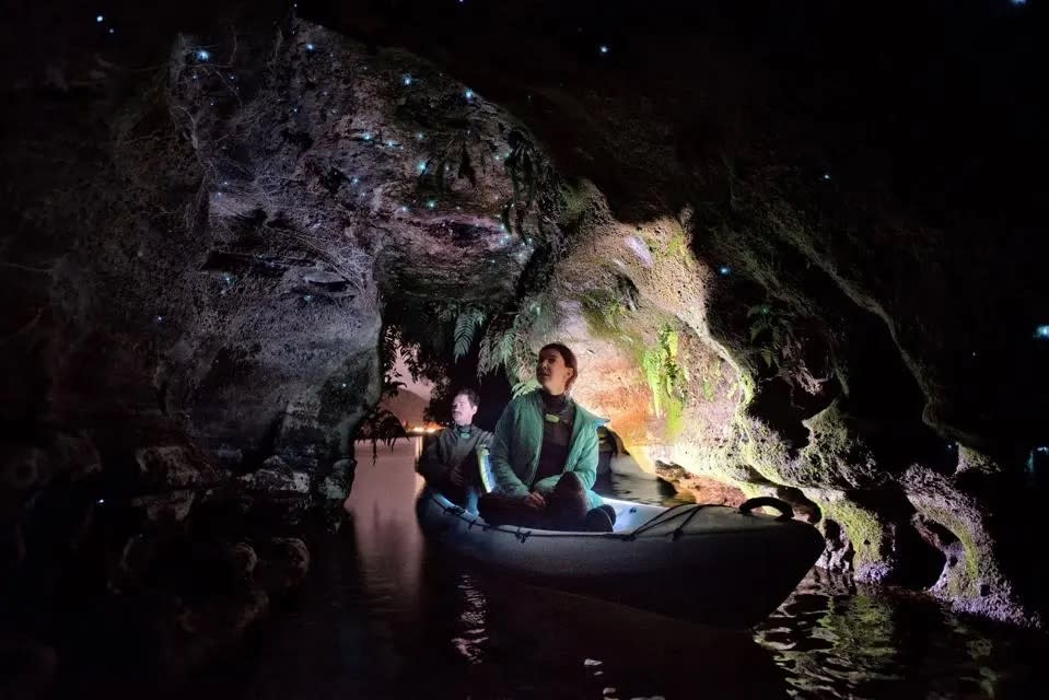 Two travelers take a kayak ride through a cave filled with glow worms in New Zealand.