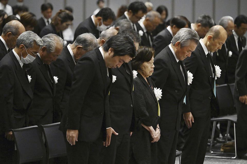 Nagasaki Mayor Shiro Suzuki, right, with other attendees takes a moment of silence during a ceremony to mark the 78th anniversary of the atomic bombing in Nagasaki, southern Japan Wednesday, Aug. 9, 2023. The ceremony was held indoors and scaled down due to approaching Tropical Storm Khanun. (Kyodo News via AP)