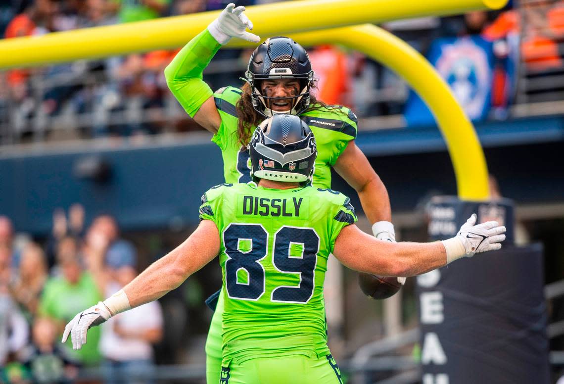 Seattle Seahawks tight end Colby Parkinson (84) celebrates with Seattle Seahawks tight end Will Dissly (89) in the end zone after scoring a touchdown before the end of the second quarter of an NFL game on Monday, Sept. 12, 2022, at Lumen Field in Seattle.
