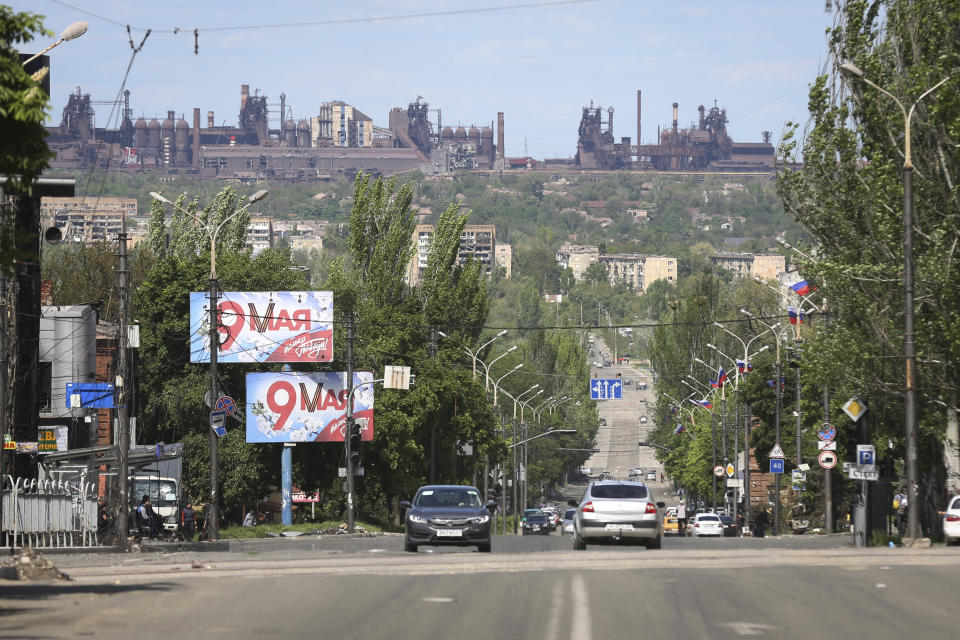 A view of a street in Mariupol, in territory under the government of the Donetsk People's Republic, eastern Ukraine, Tuesday, May 17, 2022, with the Azovstal steel plant in the background. (AP Photo/Alexei Alexandrov)