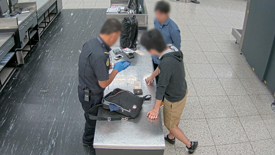 Japanese tourist Masahiro Kobayashi has his phone viewed by Australian Border Force at Perth airport. 