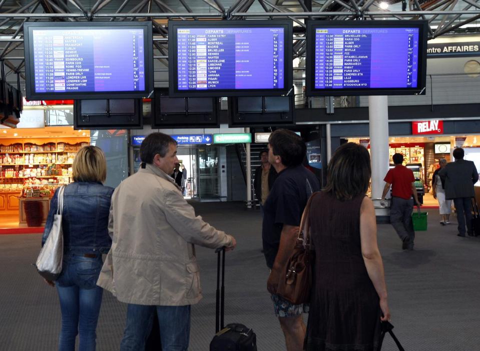 Passengers check flight information at Marseille-Provence Airport, in Marignane, southern France, Tuesday, June 11, 2013. France's main airports have cut their flight timetables in half to cope with a three-day strike by air traffic controllers. The Civil Aviation Authority said that some 1,800 flights were cut Tuesday in France to protest against a plan to centralize control of Europe's air space. (AP Photo/ClaudeParis)