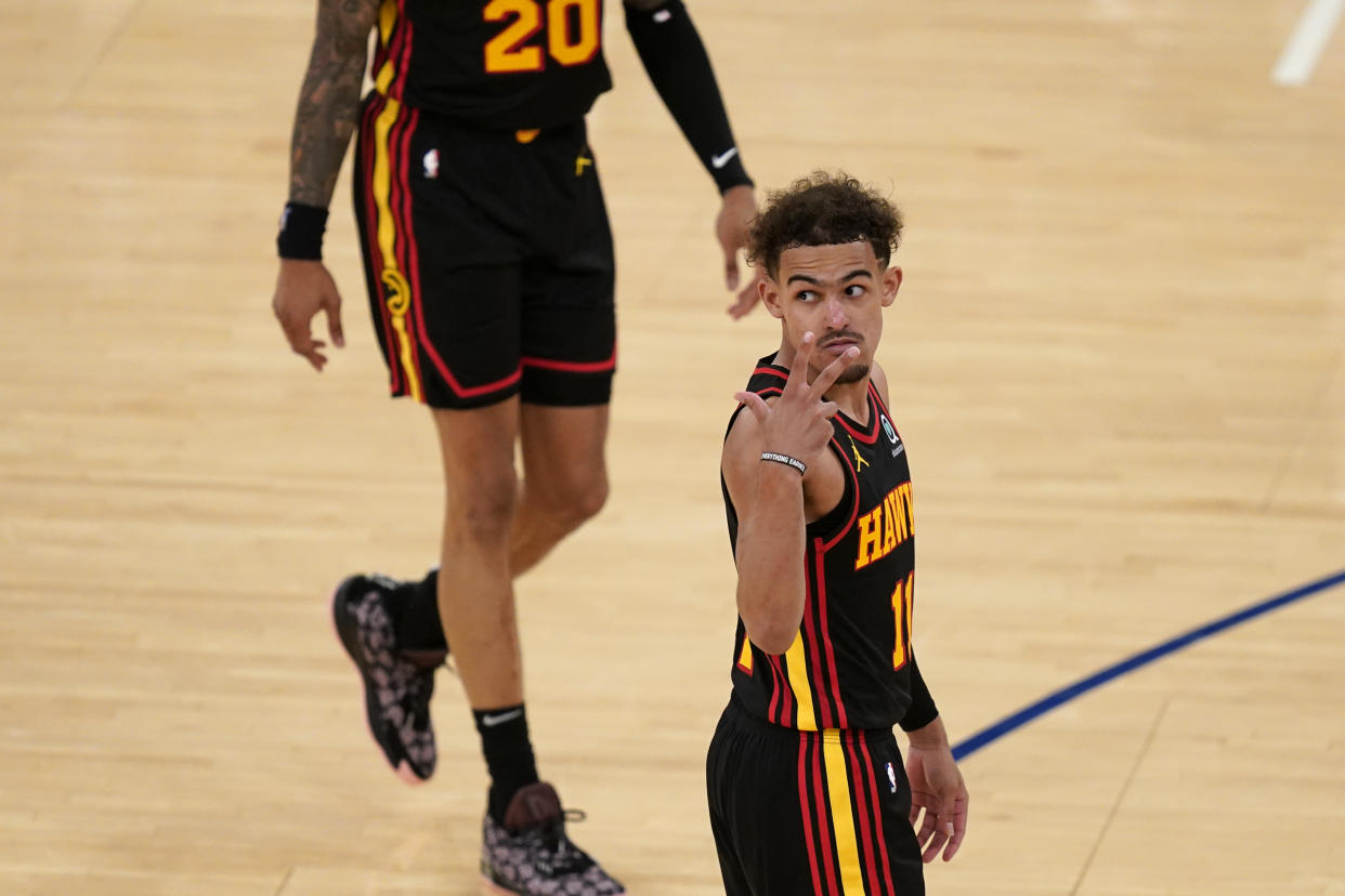 Trae Young gestures with three fingers.