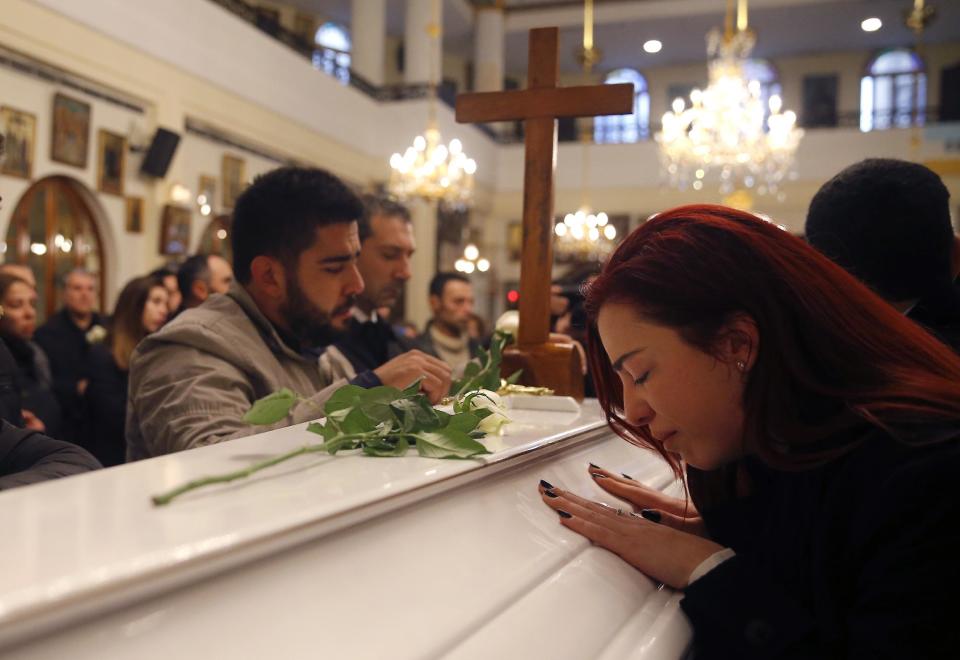 Relatives and friends of Elias Wardini, a Lebanese man who was killed in Istanbul nightclub attack, mourn over his coffin, at a church, in Beirut, Lebanon, Tuesday, Jan. 3, 2017. Three Lebanese citizens were killed in the shooting and four injured. (AP Photo/Hussein Malla)