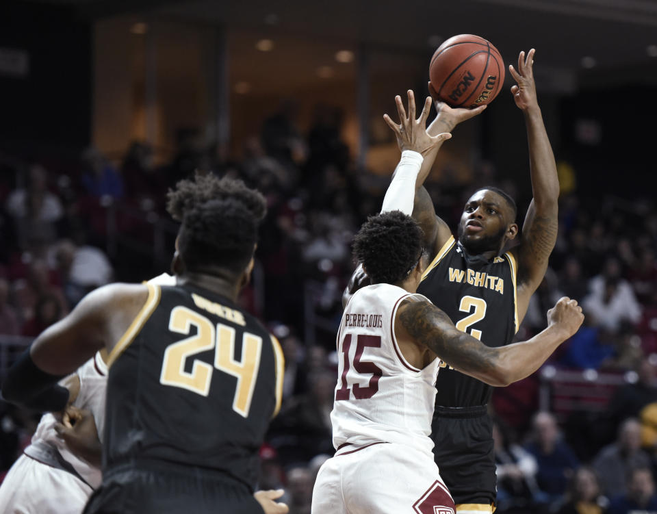 Wichita State's Jamarius Burton (2) shoots over Temple's Nate Pierre-Louis (15) during the first half of an NCAA college basketball game Wednesday, Jan. 15, 2020, in Philadelphia. (AP Photo/Michael Perez)