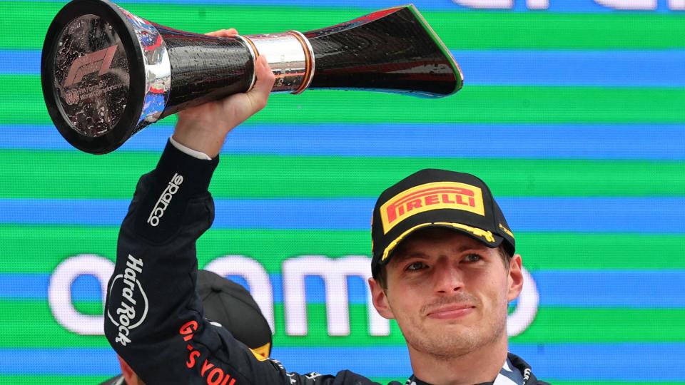 Max Verstappen holds the winner's trophy above his head after winning the Spanish Grand Prix