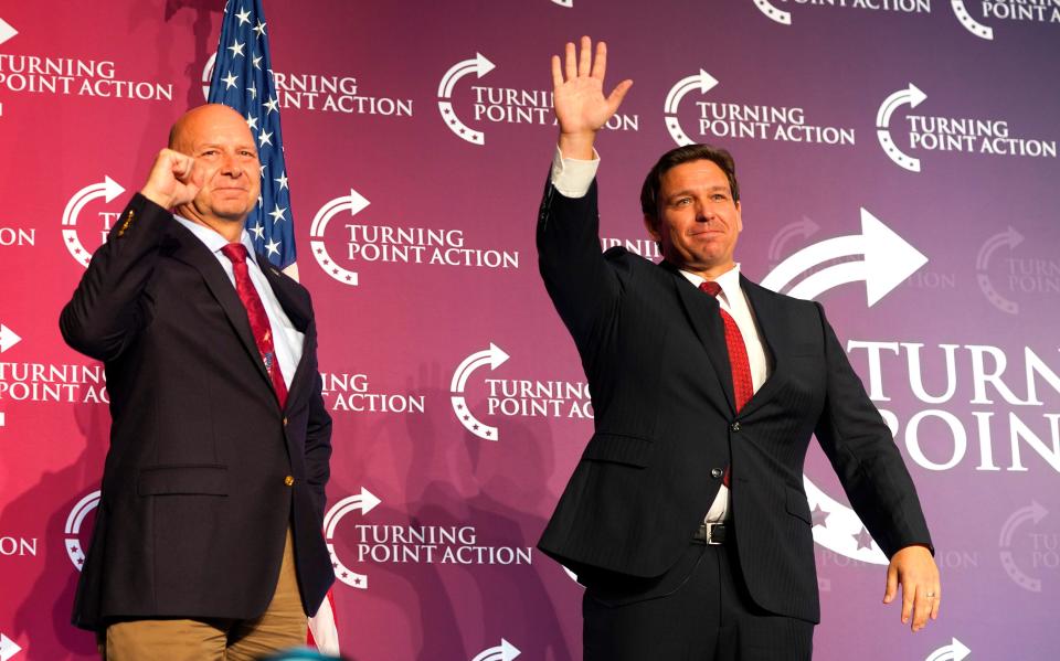 Republican nominee for Pennsylvania Gov. Doug Mastriano, left, and Florida Gov. Ron DeSantis gesture to the crowd at the end of Turning Point Action's "Unite and Win" Rally on Aug. 19.