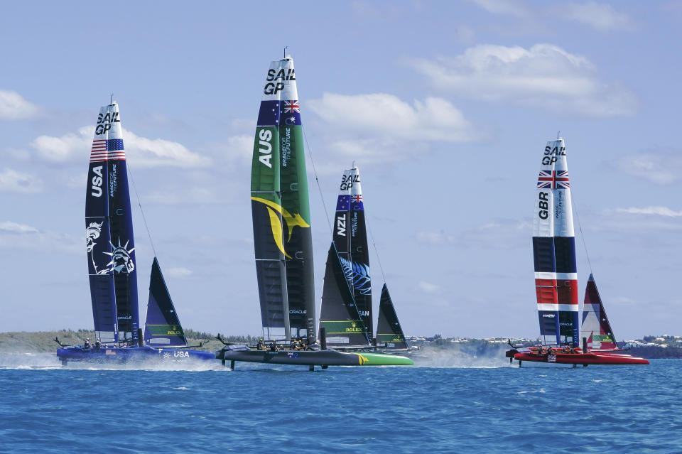 In this photo provided by SailGP, from left to right, the USA, Australia, New Zealand and Britain SailGP teams compete during the Bermuda SailGP in Hamilton, Bermuda, on Friday, April 23, 2021. Skipper Tom Slingsby and defending champion Team Australia won all three fleet races Friday on Bermuda's Great Sound in an impressive performance on the first day of the second season of the SailGP global league. (Thomas Lovelock/SailGP via AP)