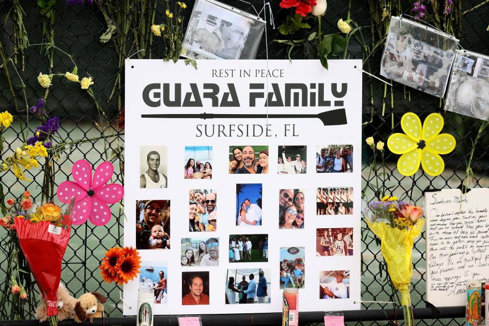 A sign with pictures of Anaely Rodriguez, her husband Marcus Guara and their daughters Lucia Guara, and Emma Guarahangs hang in the memorial that has pictures of some of the missing from the partially collapsed 12-story Champlain Towers South condo building on July 07, 2021, in Surfside, Florida.