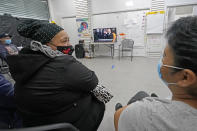 Immigrant worker Blanca Cedillos, center, who is a nanny, glances over at cleaning lady Graciela Uraga, as they watch the presidential inauguration from the Workers Justice Center, a center that supports immigrant workers rights, Wednesday, Jan. 20, 2021, in the Sunset Park neighborhood of Brooklyn in New York. Cedillos admitted to being "nervous" listening to President Joe Biden's speech, but said she was disappointed he didn't say anything about immigration reform. (AP Photo/Kathy Willens)