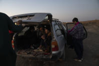 Afghan migrants get in a car near the village of Islam Qala, on Wednesday, Nov. 24, 2021 to drive near the Afghanistan-Iran border in their effort to cross Iran. Afghans are streaming across the border into Iran, driven by desperation after the near collapse of their country's economy following the Taliban's takeover in mid-August. In the past three months, more than 300,000 people have crossed illegally into Iran, according to the Norwegian Refugee Council, and more are coming at the rate of 4,000 to 5,000 a day. (AP Photo/Petros Giannakouris)