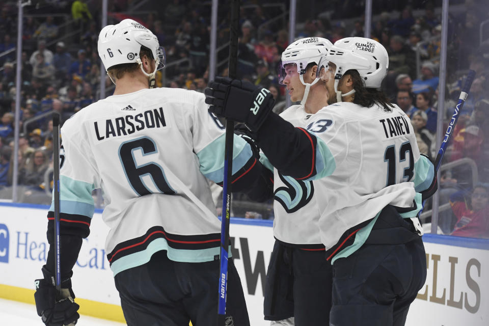 Seattle Kraken's Morgan Geekie (67), Brandon Tanev (13) and Adam Larsson (6) celebrate a goal during the first period of an NHL hockey game against the St. Louis Blues, Tuesday, Feb. 28, 2023, in St. Louis. (AP Photo/Michael Thomas)