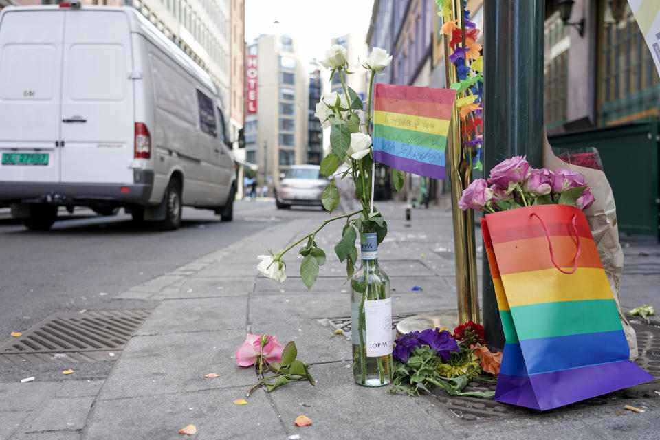 Flores acompañadas por los colores del orgullo gay yacen en el sitio donde un hombre armado se puso a disparar, el sábado 25 de junio de 2022, en el centro de Oslo. (Hakon Mosvold Larsen/NTB Scanpix vía AP)