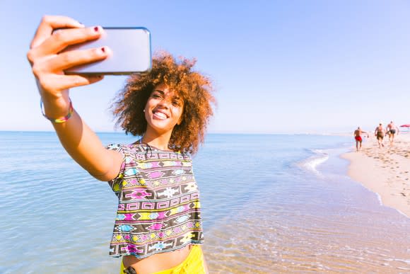 A young woman takes a selfie.