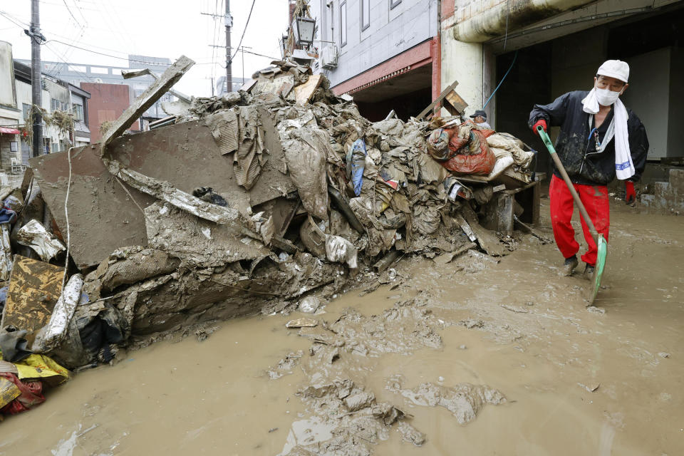 A man tries to shovel mud out from a building affected by a heavy rain in Hitoyoshi, Kumamoto prefecture, southern Japan Thursday, July 9, 2020. Pounding rain spread to central Japan and triggered mudslides. (Kyodo News via AP)