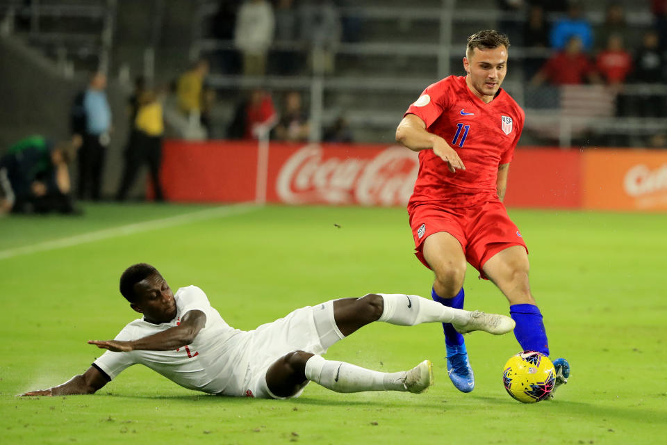 Jordan Morris (11) tries to avoid the tackle of Canada's Richie Laryea on Friday in Orlando. The USMNT won 4-1 in the CONCACAF Nations League. (Photo by Sam Greenwood/Getty Images)