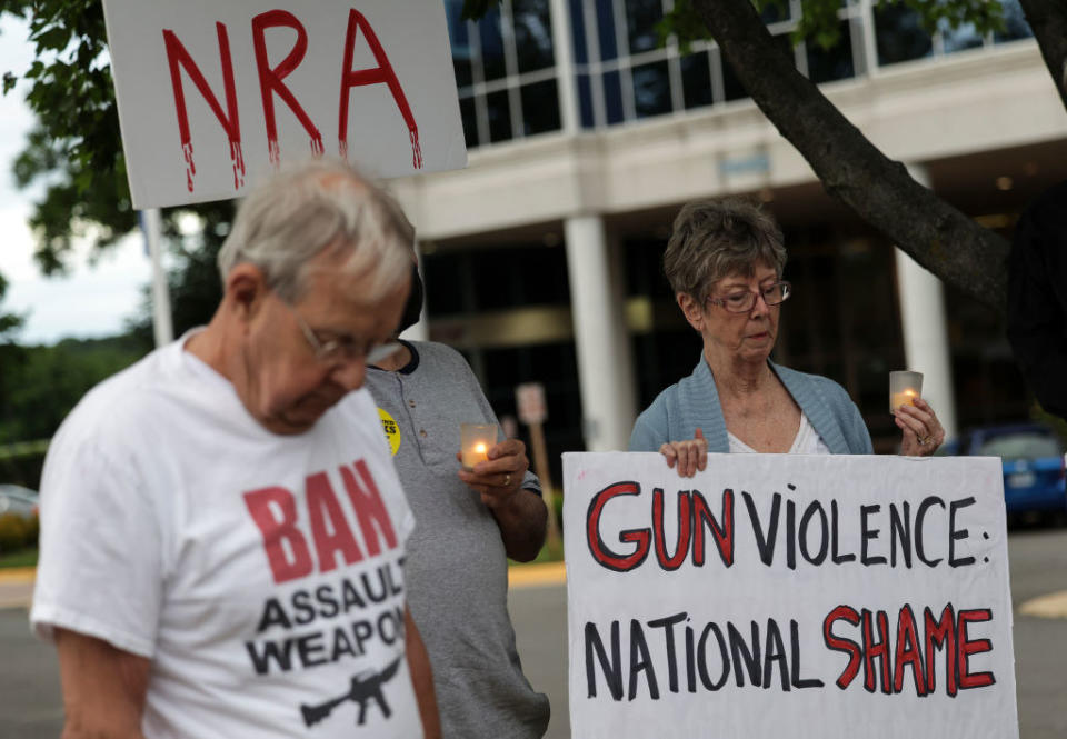 older people holding signs reading gun violence is a national shame