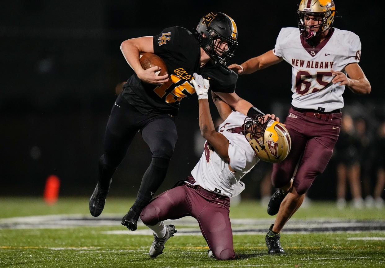 Upper Arlington's Tommy Janowicz takes on a New Albany tackler during a game in 2022.