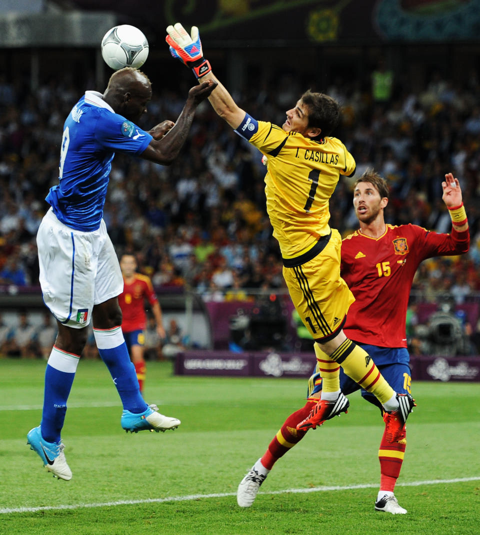 KIEV, UKRAINE - JULY 01: Iker Casillas (C) of Spain stretches for the ball in front of team-mate Sergio Ramos (R) as Mario Balotelli of Italy attempts to head at goal during the UEFA EURO 2012 final match between Spain and Italy at the Olympic Stadium on July 1, 2012 in Kiev, Ukraine. (Photo by Jasper Juinen/Getty Images)