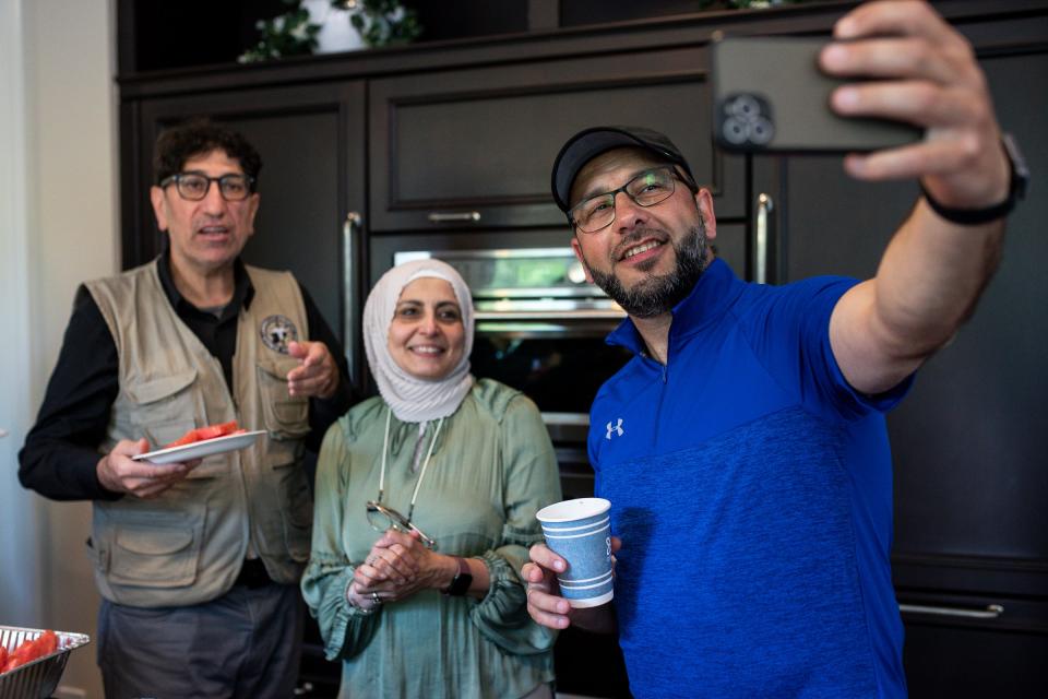 Anas Alrifai, a family friend, takes a selfie with Dr. Ammar Ghanem and his wife Amnah Allboani Ghanem at home in West Bloomfield on Saturday, May 18, 2024.