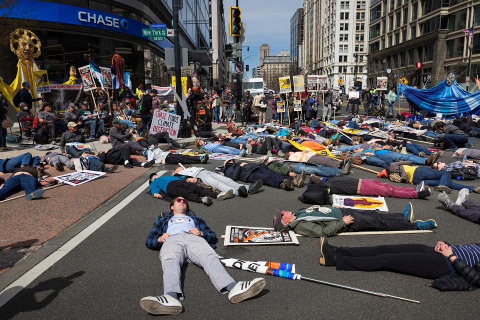 street full of people lying down playing dead with colorful picket signs