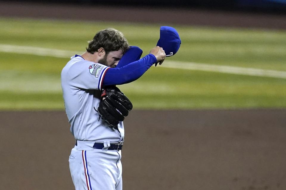 Texas Rangers starting pitcher Jordan Lyles wipes sweat from his face after giving up a run to the Arizona Diamondbacks during the fourth inning of a baseball game Tuesday, Sept. 22, 2020, in Phoenix. (AP Photo/Ross D. Franklin)