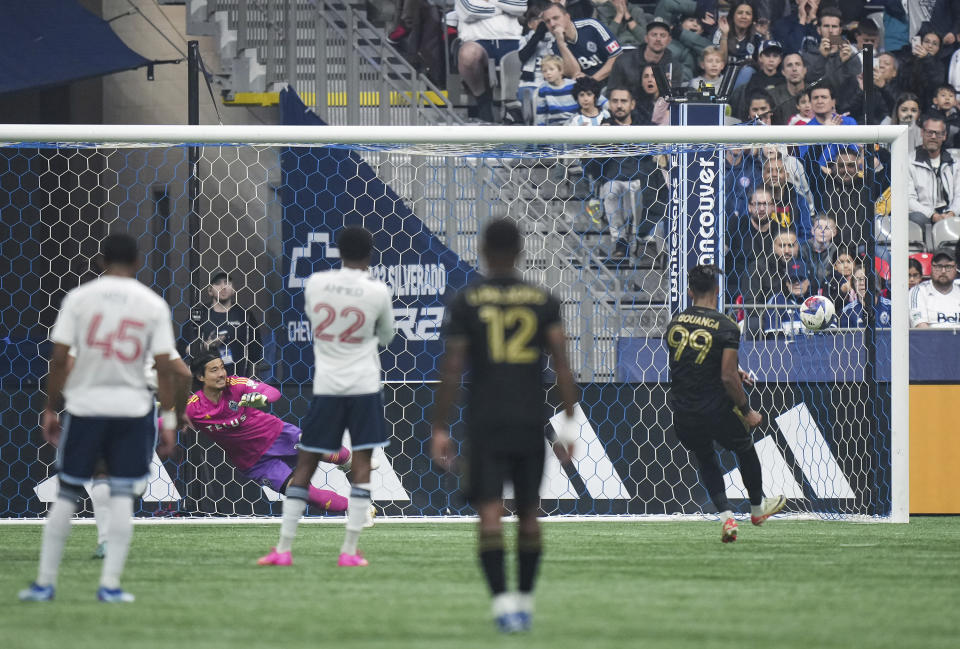 Los Angeles FC's Denis Bouanga (99) scores against Vancouver Whitecaps goalkeeper Yohei Takaoka, back left, on a penalty kick during the first half in Game 2 of a first-round MLS playoff soccer match in Vancouver, British Columbia, Sunday, Nov. 5, 2023. (Darryl Dyck/The Canadian Press via AP)