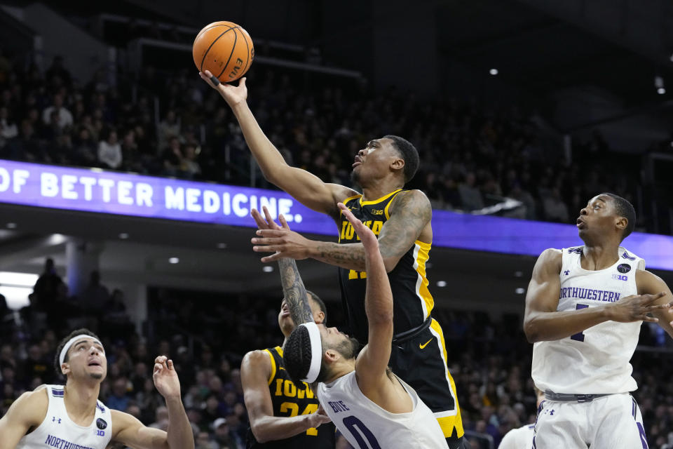 Iowa guard Tony Perkins, top, drives to the basket against Northwestern guard Boo Buie during the first half of an NCAA college basketball game in Evanston, Ill., Sunday, Feb. 19, 2023. (AP Photo/Nam Y. Huh)