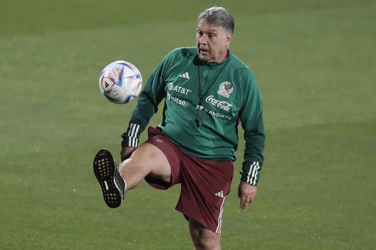 Mexico's coach Gerardo Martino plays a ball during a training session in Jor, Qatar, Wednesday, Nov. 23, 2022. (AP Photo/Moises Castillo)