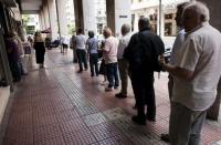 People queue at a bank ATM in Athens