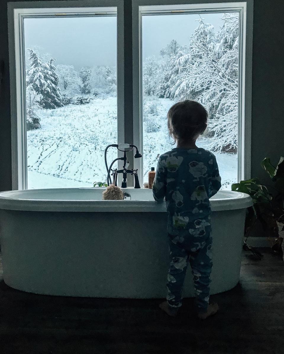 Cash, 3, stands in front of a standalone tub in his new home.