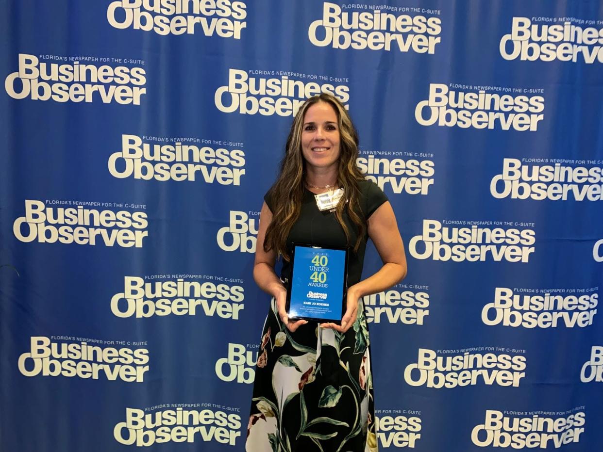 Kari-Jo Koshes, of JMX Brands, with her "40 Under 40" award from the Business Observer.