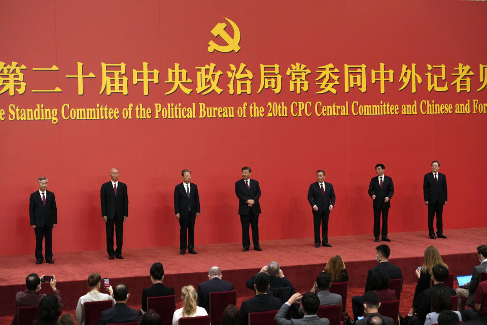 New members of the Politburo Standing Committee, from left, Li Xi, Cai Qi, Zhao Leji, President Xi Jinping, Li Qiang, Wang Huning, and Ding Xuexiang are introduced at the Great Hall of the People in Beijing, Sunday, Oct. 23, 2022. (AP Photo/Ng Han Guan)