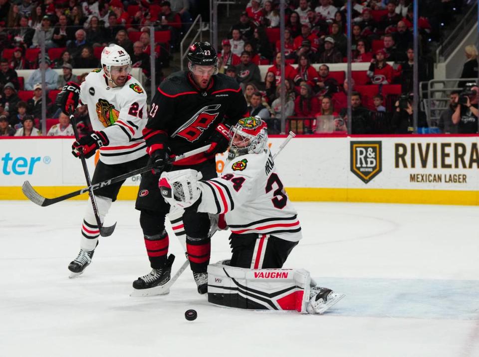 Feb 19, 2024; Raleigh, North Carolina, USA; Chicago Blackhawks goaltender Petr Mrasek (34) makes a save against Carolina Hurricanes right wing Stefan Noesen (23) during the first period at PNC Arena. Mandatory Credit: James Guillory-USA TODAY Sports