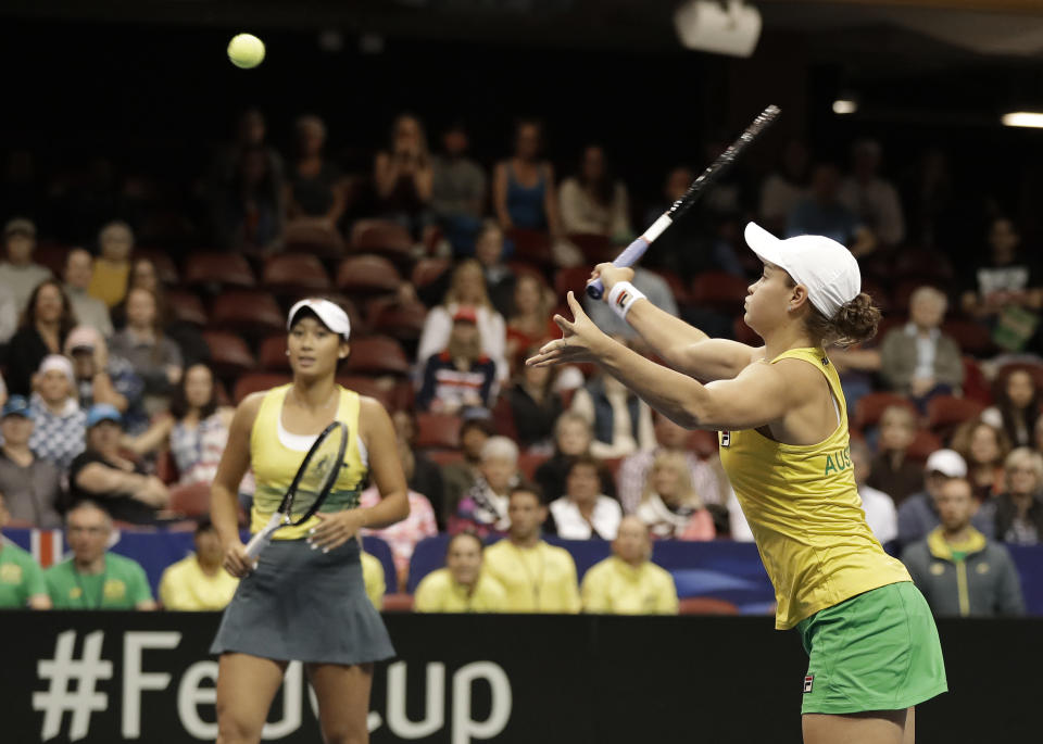 La australiana Ashleigh Barty, derecha, devuelve un tiro a las estadounidenses Danielle Collins y Nicole Melichar, mientras su compañera Priscilla Hon, izquierda, observa durante su duelo de dobles de la Copa Federación en Asheville, Carolina del Norte, el domingo 10 de febrero de 2019. (AP Foto/Chuck Burton)