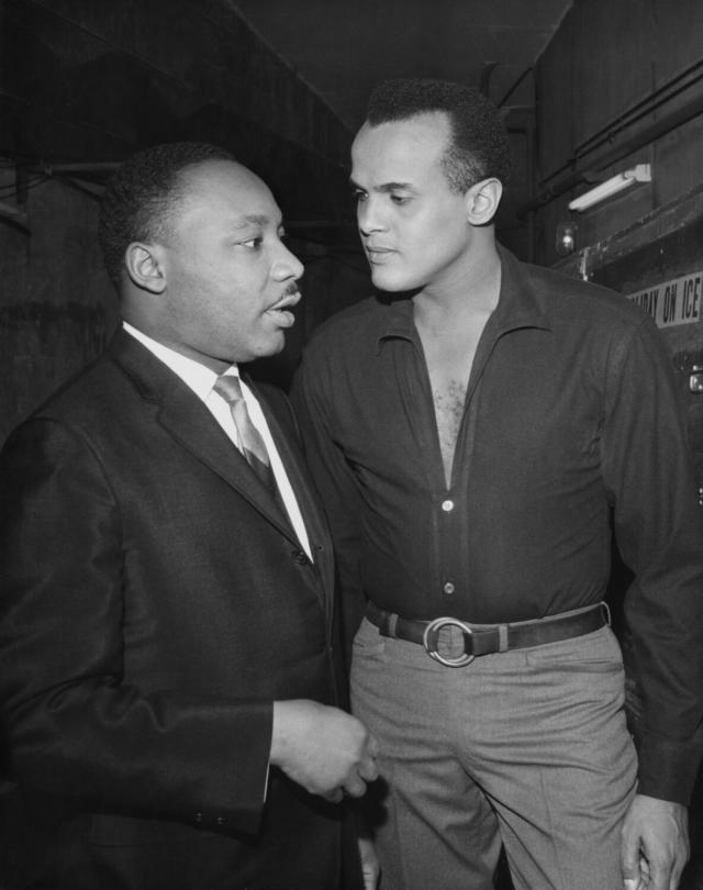 A black-and-white vertical frame of Martin Luther King Jr, at left, and Harry Belafonte, talking together