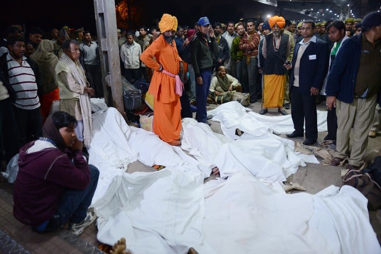 Officials stand among some of the travellers that were killed during a stampede at the railway station in Allahabad, on February 10, 2013. At least 36 people died in a terrifying stampede as pilgrims headed home from India's Kumbh Mela religious festival, which drew a record 30 million people to the banks of the Ganges