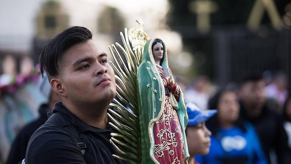 Joven con una imagen de la Virgen de Guadalupe