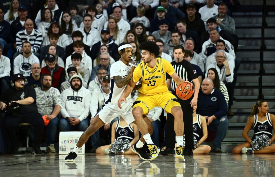 Michigan Wolverines forward Olivier Nkamhoua controls the ball against Penn State Nittany Lions guard Nick Kern Jr. in the first half at the Palestra on Jan. 7, 2024, in Philadelphia, Pa.