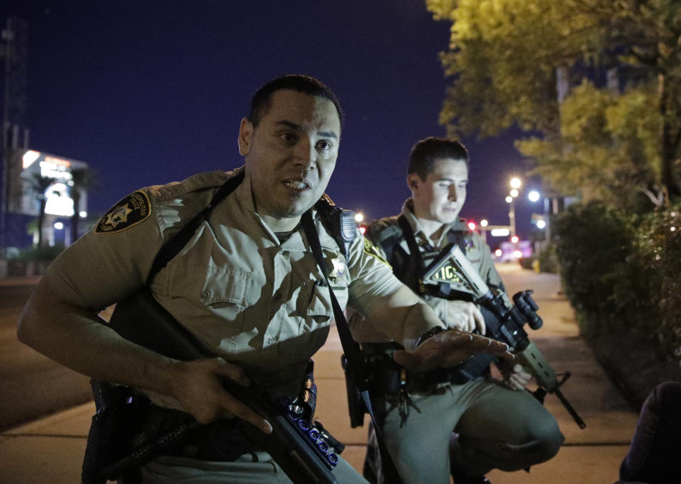 <p>Police officers advise people to take cover near the scene of a shooting near the Mandalay Bay resort and casino on the Las Vegas Strip, Oct. 1, 2017, in Las Vegas. (Photo: John Locher/AP) </p>